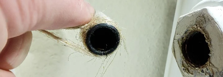 Hand hält Hanfseil an Heizungsrohr