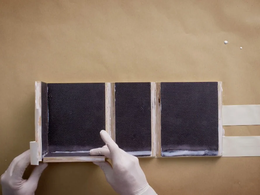 Person klebt Holzteile zusammen