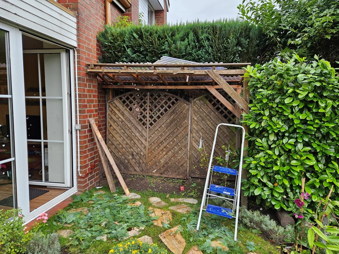 Unfertiger Holzunterstand mit einer Leiter im Garten