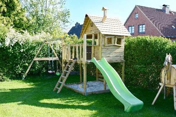 Ein Holzspeilplatz mit Rutsche und Schaukel im Garten.