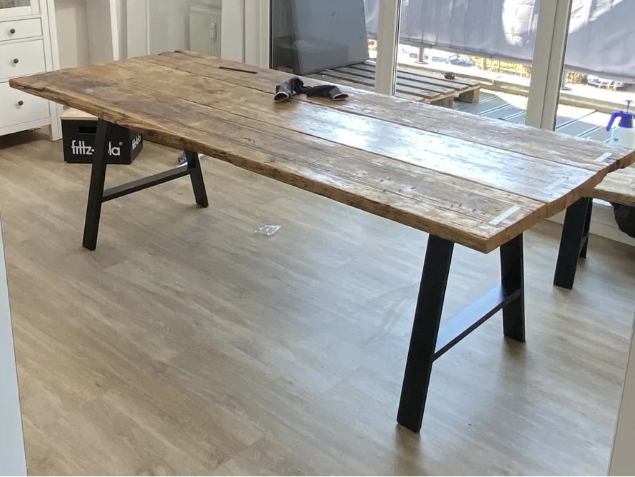 Großer Esstisch aus Holz mit schwarzen Metallbeinen