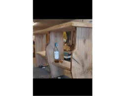 Rustikales Holzregal mit einer Flasche und einem Glas