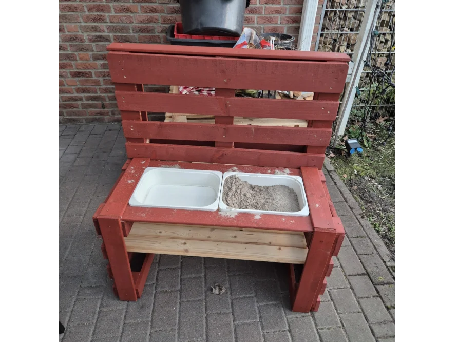 Roter Sandkasten aus Palettenholz