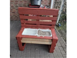 Roter Sandkasten aus Palettenholz