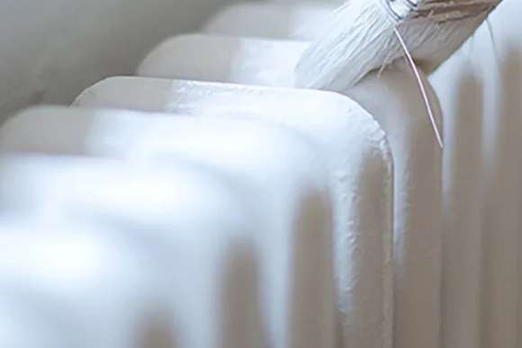 Heizkörper wird mit Pinsel gestrichen