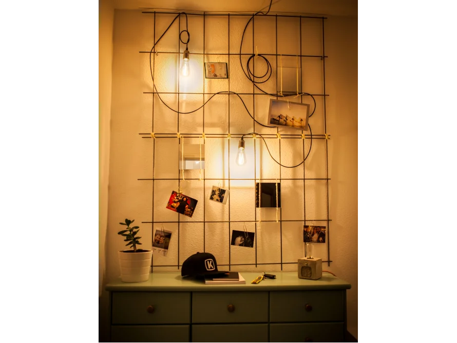 Metallgitter mit Fotos und Lichtern