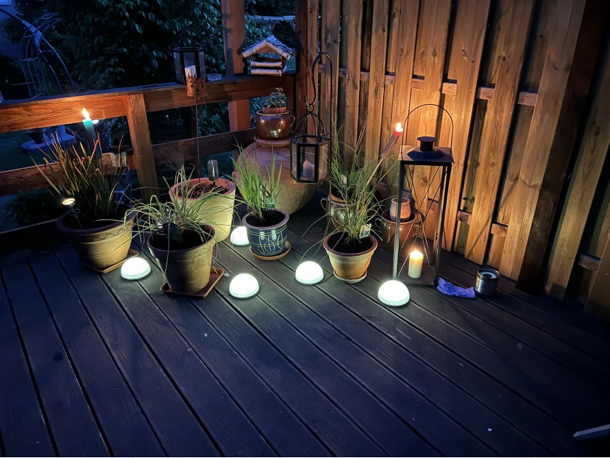 Beleuchtete Holzterrasse mit Pflanzen