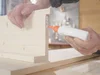 Person verklebt Holz mit Klebstoff