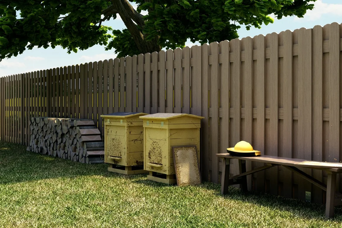 Zwei Bienenstöcke an einem Gartenzaun