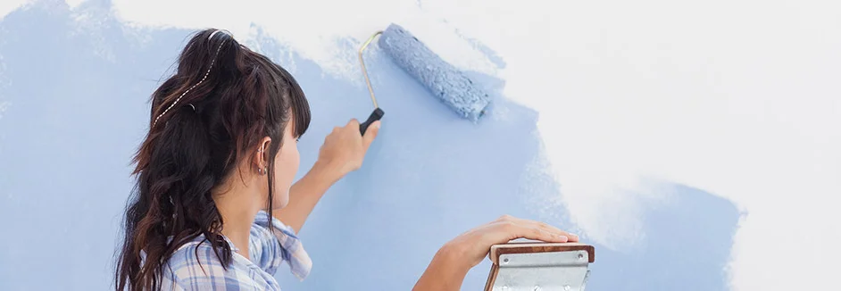 Person streicht Wand blau