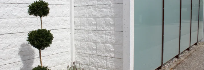 Gartenzaun aus weissen Steinen und Milchglas