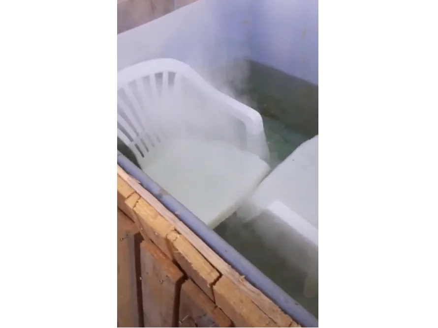 Zwei weiße Plastikstühle in einer Wanne