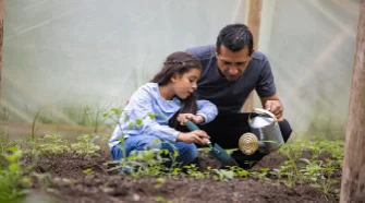 Person und Kind pflanzen mit Gießkanne
