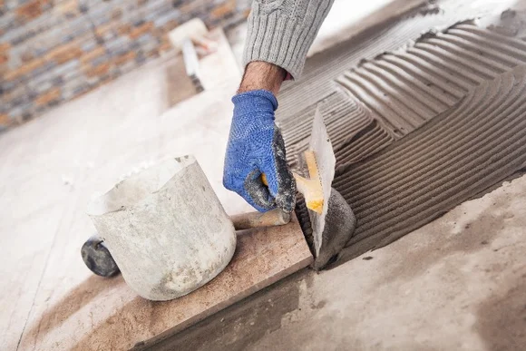 Hand verlegt Fliesenkleber mit Kelle