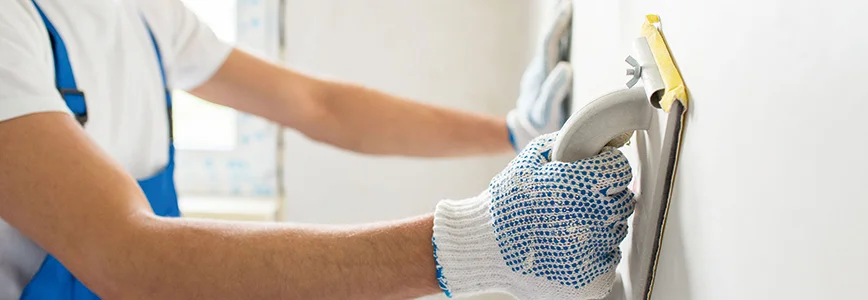 Person verputzt Wand