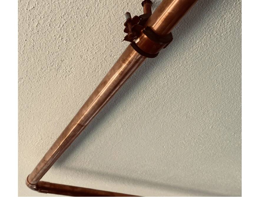 Kupferrohr an Wand befestigt