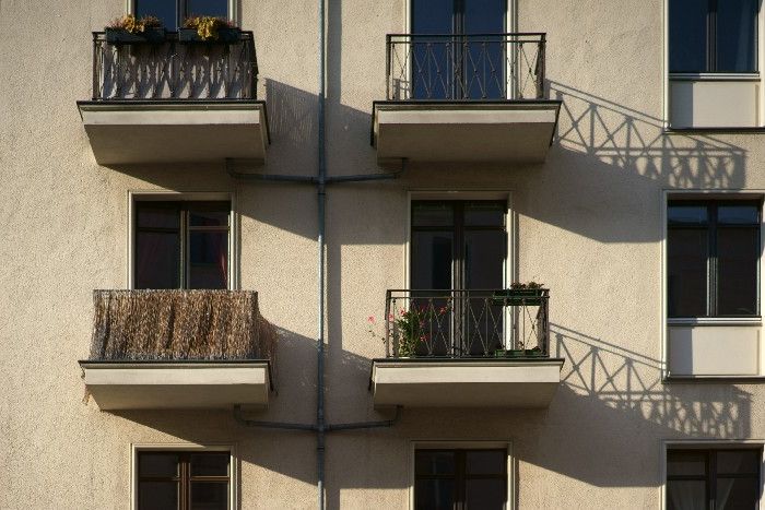 Vier kleine Balkone mit unterschiedlichen Sichtschutzvorrichtungen.