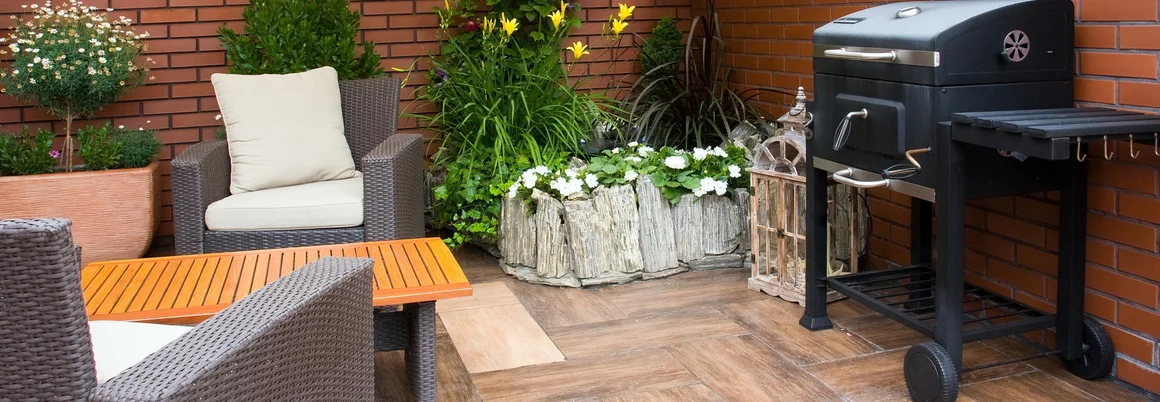 Gemütliche Terrasse mit Grill und Gartenmöbeln