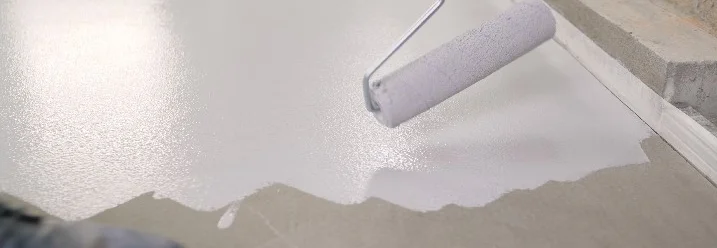 Boden wird mit Farbe und Farbrolle gestrichen