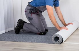 Mann rollt Teppichboden aus