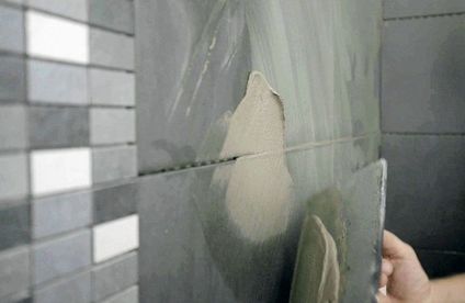 Wandfliesen verfugen Fugenmasse wird auf Wandfliesen gestrichen.