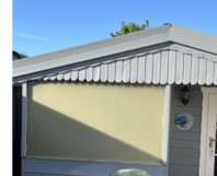 Gartenhauswand mit Stuhl