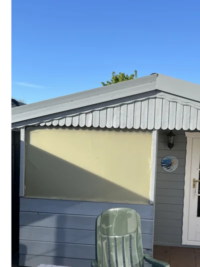 Gartenhauswand mit Stuhl