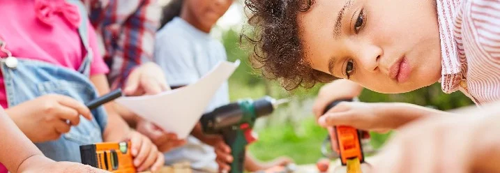 Kind misst Holz mit Zollstock