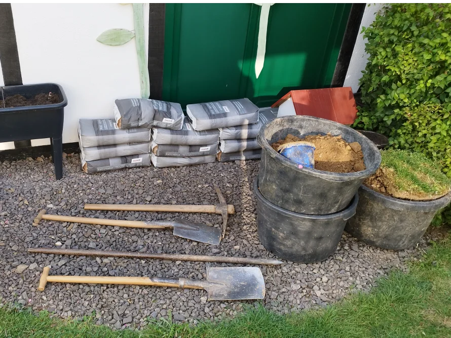 Gartengeräte und Säcke mit Kies