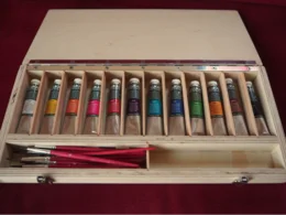 Holzkasten mit Farbtuben und Pinseln