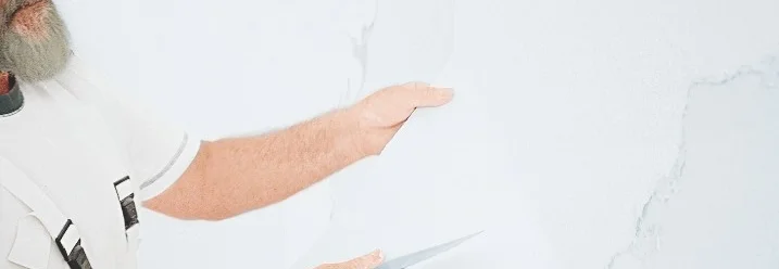 Person trägt Spachtelmasse auf Wand auf