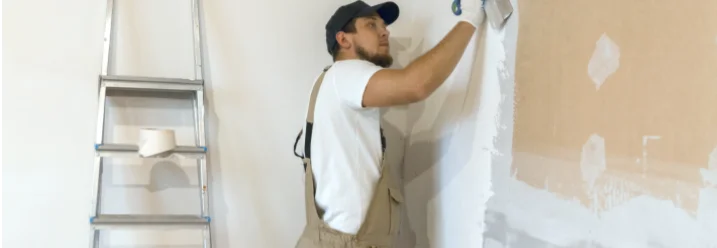 Person verspachtelt eine Wand