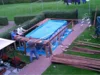 Drei Personen bauen einen Pool im Garten auf