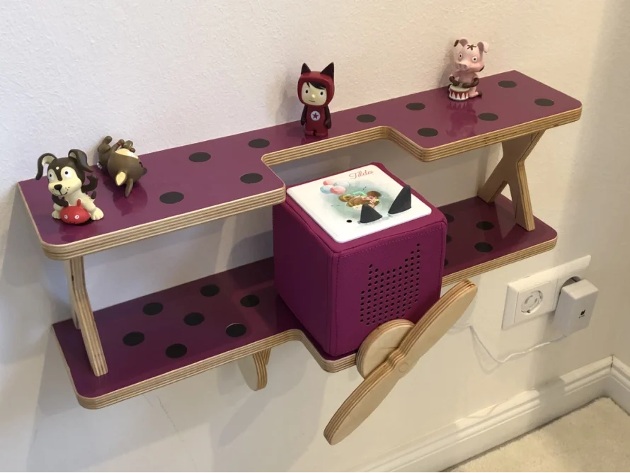 Wandregal in Flugzeugform mit Spielzeug