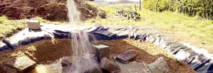 Teichfolie wird mit Wasser befüllt