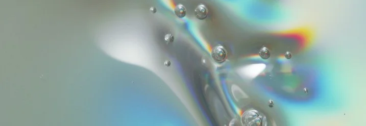 Abstrakte Ansicht von Seifenblasen auf einer schillernden Oberfläche.