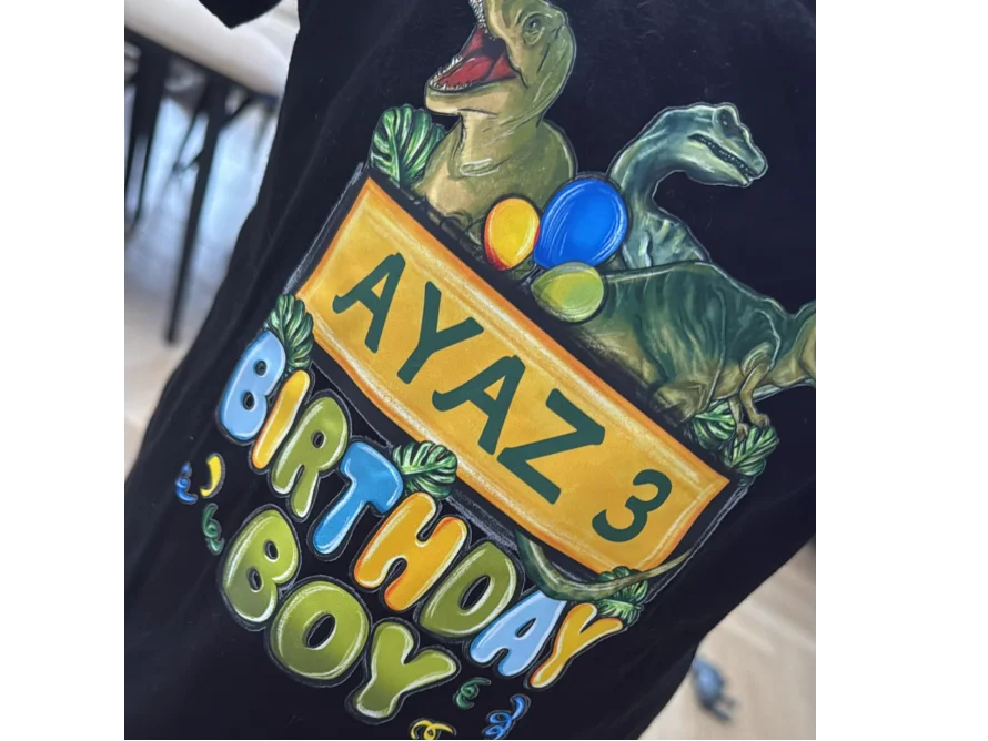 Schwarzes T-Shirt mit Dinosauriern und der Aufschrift "AYAZ 3 BIRTHDAY BOY"