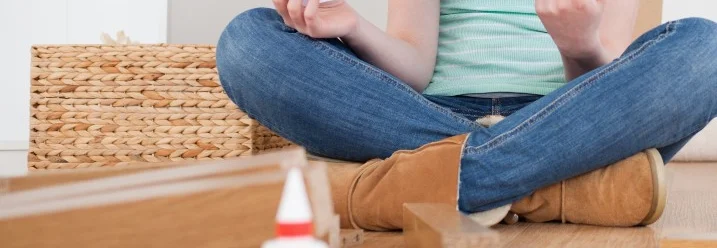 Person baut Möbel zusammen