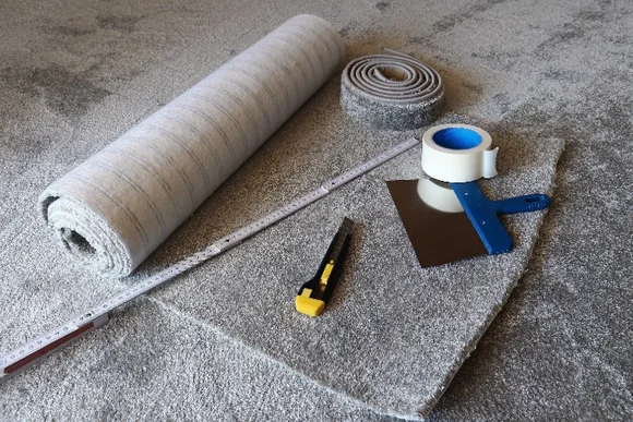 Teppichboden, Cuttermesser und Zollstock