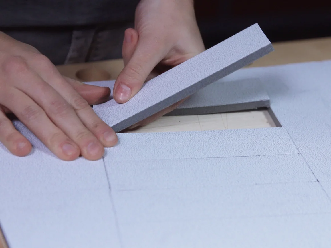 Person schneidet Dämmmaterial mit Messer