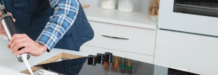 Person trägt Dichtmasse mit Kartuschenpistole auf