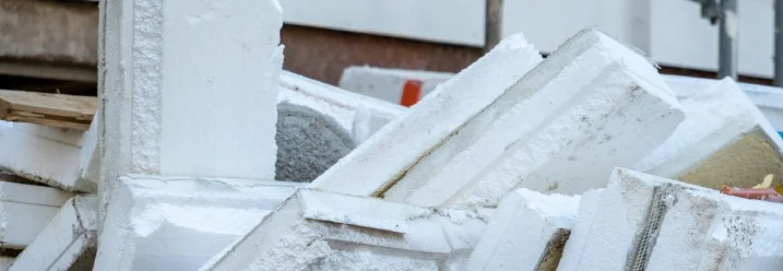 Ein Haufen alter Dämmplatten auf einer Baustelle.