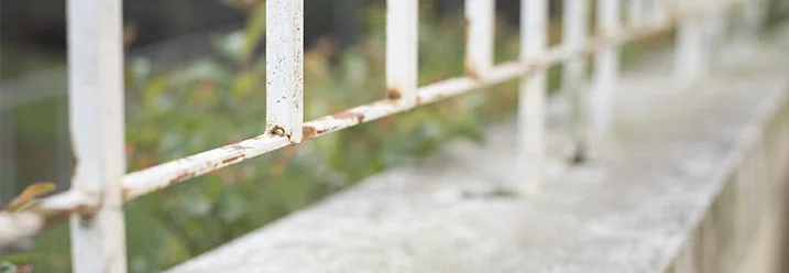 Weißer Metallzaun mit Rost