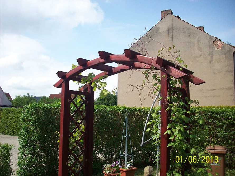 Ein Rankbogen aus Holz in einem Garten