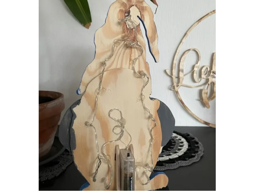 Holzpinguin mit Lichterkette von hinten