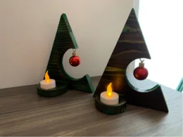 Zwei grüne Holz-Weihnachtsbäume mit Kerzen und Kugeln