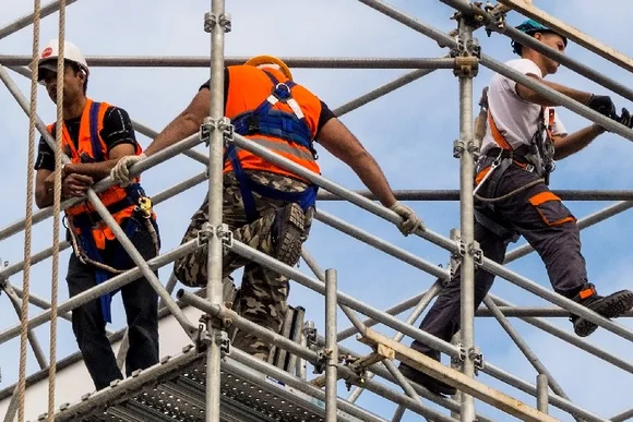 Drei Bauarbeiter auf einem Gerüst