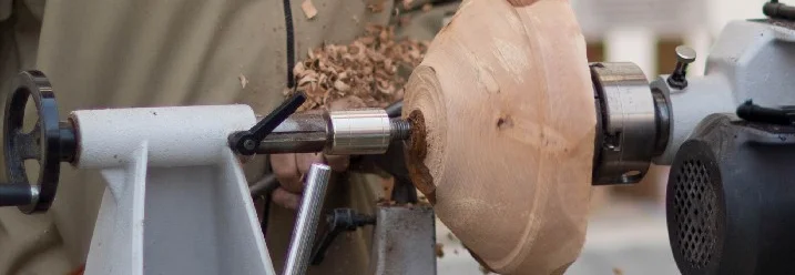 Person bearbeitet Holz auf Drechselbank