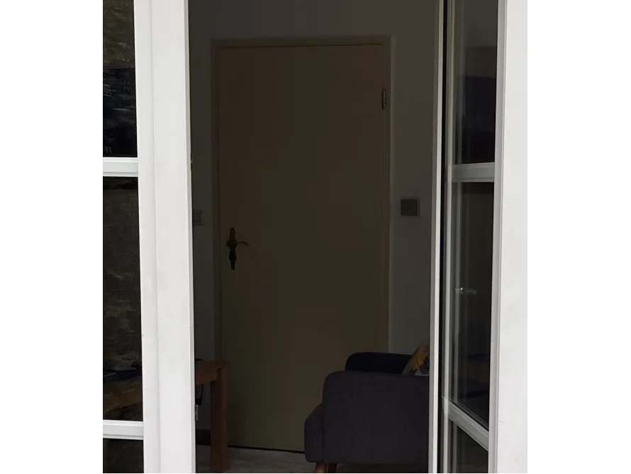 Blick durch eine offene Terrassentür in einen Raum