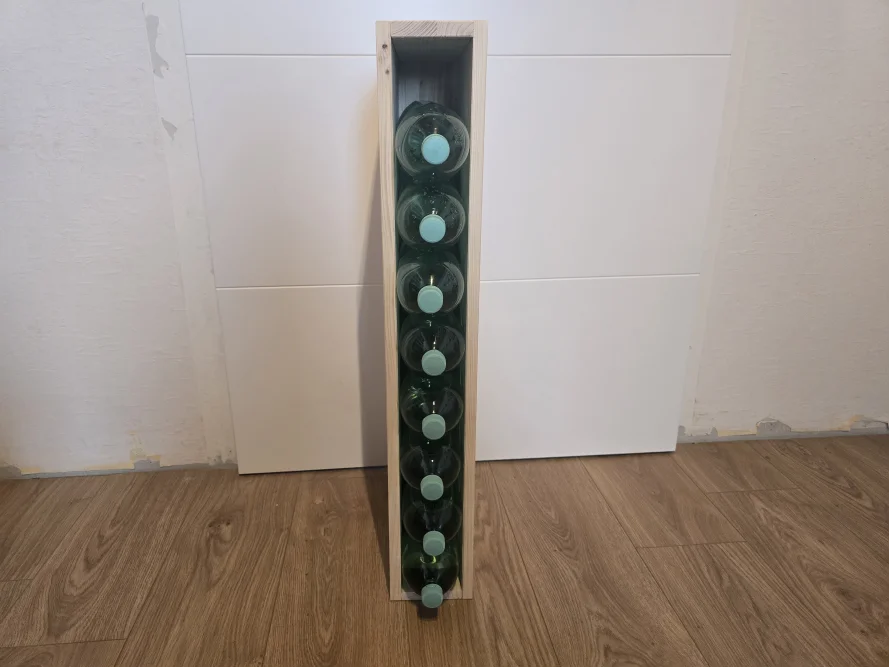 Ein schmales, hohes Weinregal aus Holz.